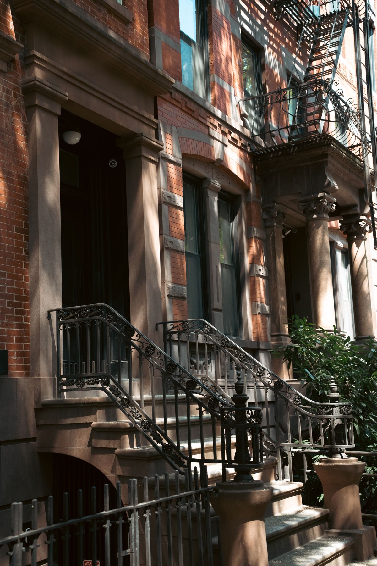 Brownstone building entrance with iron railings in New York