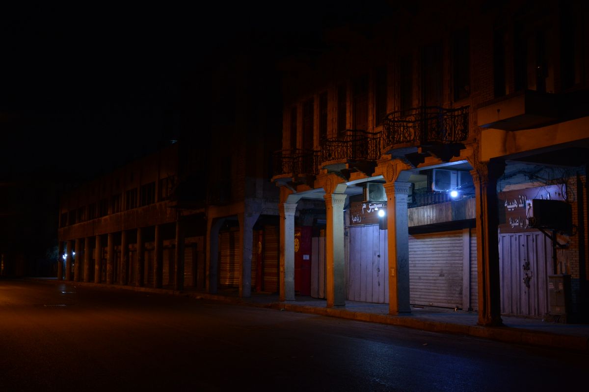 Street of closed shop shutters late at night