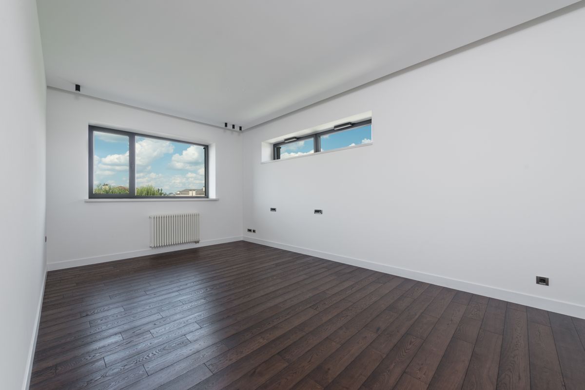 Empty apartment room with hardwood floors between tenants