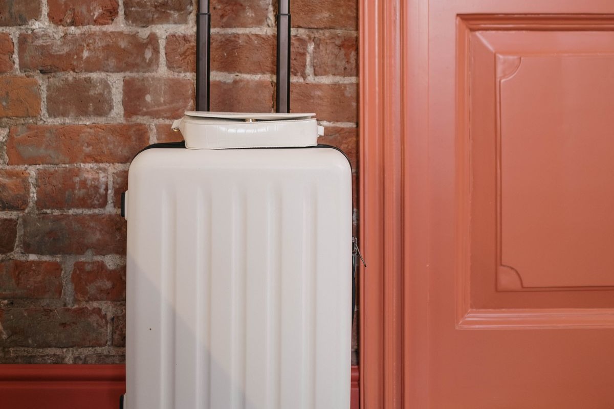 White suitcase by an apartment door, ready for an Airbnb guest check-in