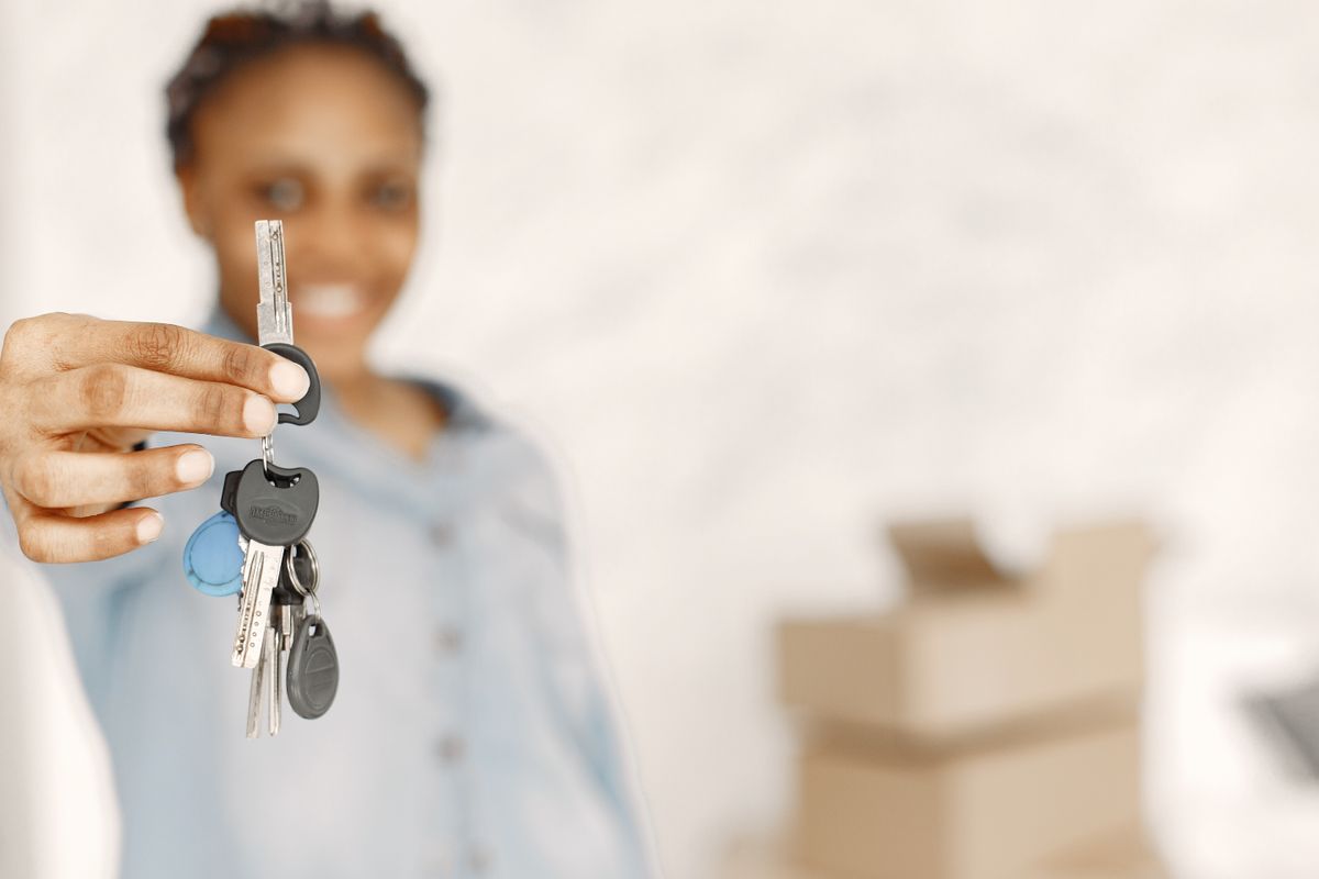 Tenant handing over a set of apartment keys with moving boxes in the background