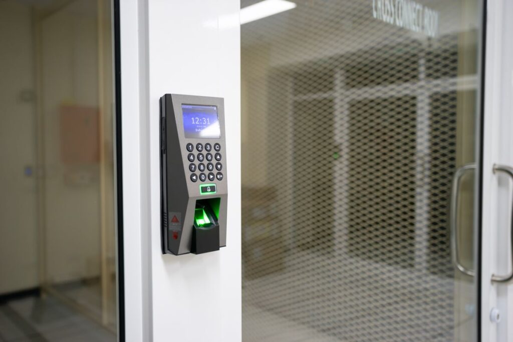 Keypad and fingerprint access control terminal mounted beside an office door